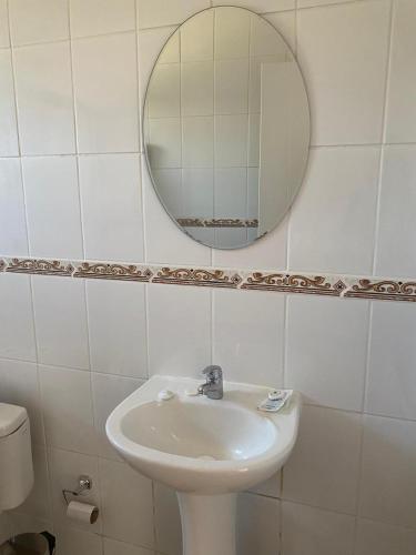 a bathroom with a sink and a mirror at Hostal Panul in Panulcillo