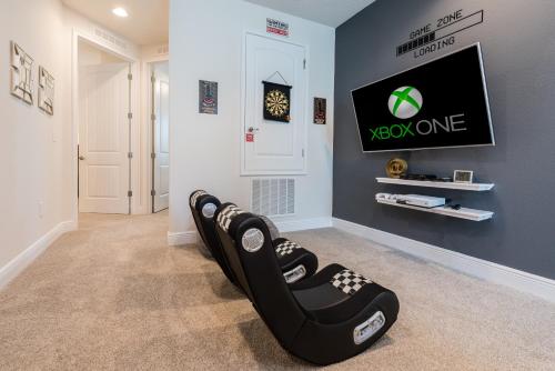 a room with a tv and a black reclining chair at Grand Home Near Disney With Private Pool, Media And Themed Rooms With Waterpark & Resort Access At Encore Resorts Reunion - 360Bu in Orlando