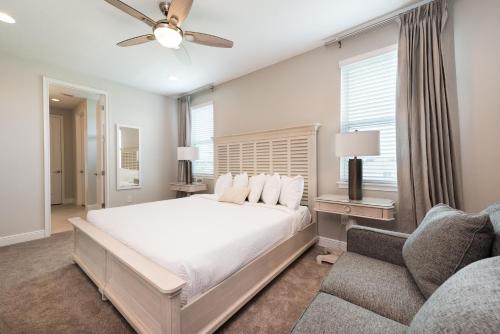 a bedroom with a white bed and a couch at Delightful Home Near Disney With Private Pool, Media Room, Waterpark & Resort Access At Encore Resort Reunion - 7418Mr in Kissimmee