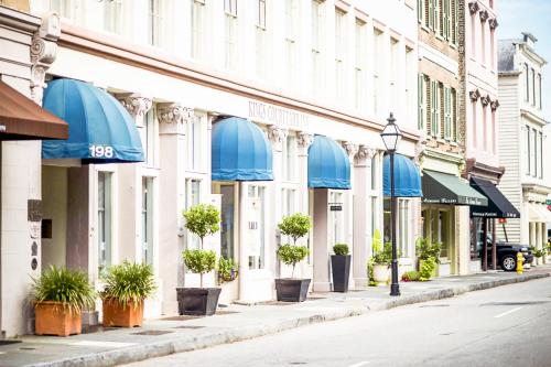 a street with buildings with blue awnings and potted plants at Kings Courtyard Inn in Charleston