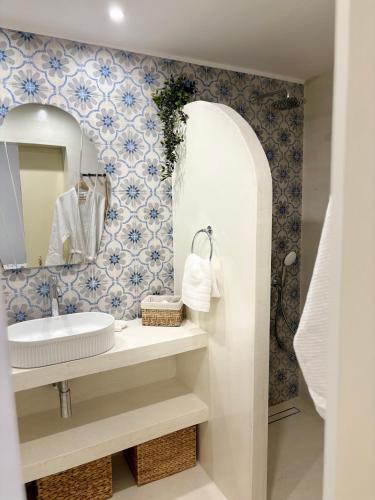 a bathroom with a sink and a mirror at Álas Holiday Home in Archangelos