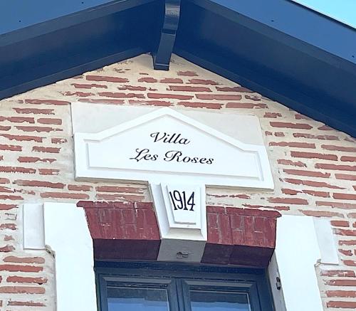 un panneau sur le côté d'un bâtiment en briques dans l'établissement VILLA DE PRESTIGE avec salle de sports privée, à Gujan-Mestras