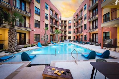 a pool at a hotel with blue chairs and buildings at 1BR Oasis w Pool&Parking, Near Rvrwlk & Conv Ctr in San Antonio