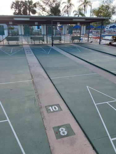 an empty tennis court with benches on it at holiday dream house in Port Charlotte