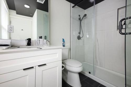 Un baño blanco con inodoro y ducha. en Sleek 2BR On Rvrwalk Gym Parking Near Conv Ctr, en San Antonio