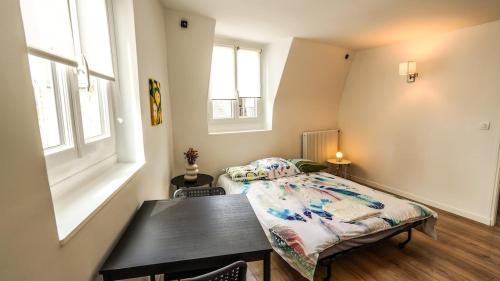 une chambre avec un lit, une table et des fenêtres dans l'établissement 09 Grand Sunny flat notre dame, à Paris