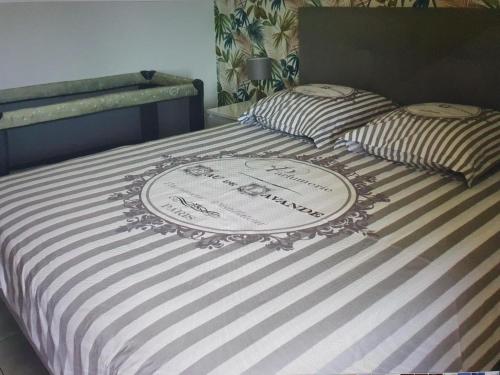 - un lit avec une couette rayée et une plaque de cuisson dans l'établissement breguières, à Antibes