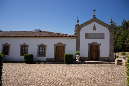 a large white church with a cross on the roof at Hotel Rural Casa de Samaioes in Chaves
