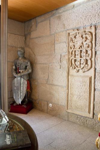 a statue of a man in a corner of a wall at Hotel Rural Casa de Samaioes in Chaves