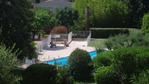 une personne assise sur un banc à côté d'une piscine dans l'établissement breguières, à Antibes
