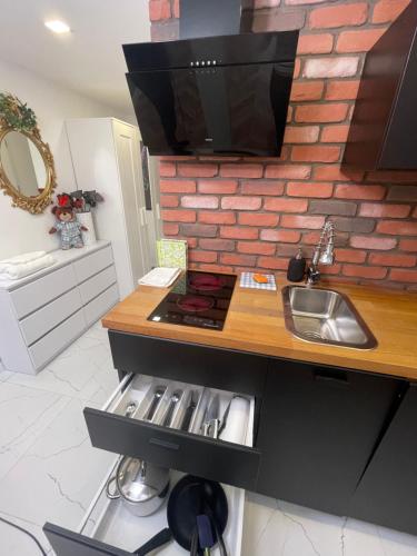 a kitchen with a sink and a counter with a sink at Loft z Antresolą i Balkonem w Centrum Łodzi Przystań Jednorożca Klimatyzacja Faktura in Łódź
