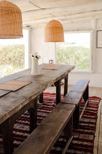 a wooden table with two benches and a vase on it at Salty House Cabo Polonio in Cabo Polonio