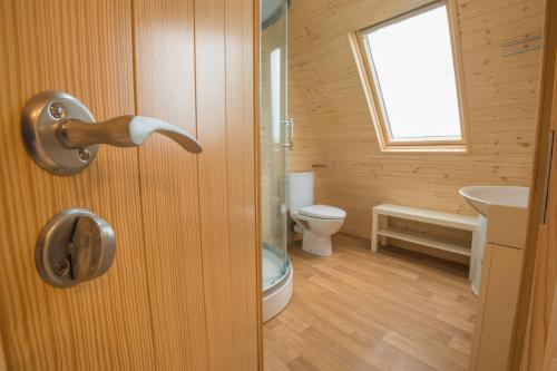 a bathroom with a door with a toilet and a sink at Lakeside Pods - pet free in Oldham