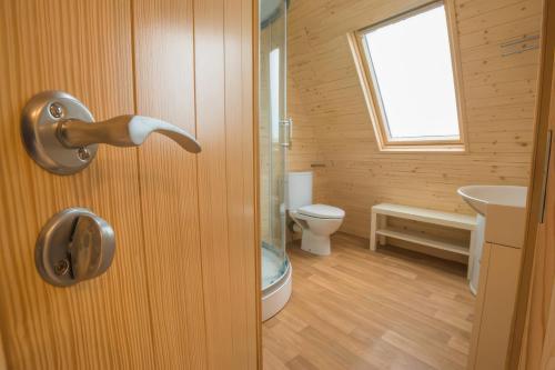 a bathroom with a door with a toilet and a sink at Lakeside Pods - pets welcome in Oldham