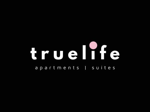 a white sign that reads tweliteagents i suites at Truelife Whitefield - Premium 1 BHK Apartments - Prime location - Easy access to Main Rd - Metro - ITPL - Fast WiFi - Kitchen - Smart TV - Power backup - Park - Garden views in Bengaluru