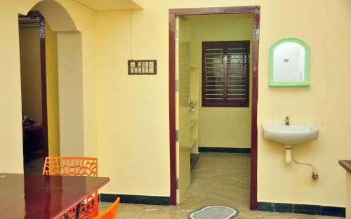 a bathroom with a sink in a room with a table at Rayar Residency in Cuddalore