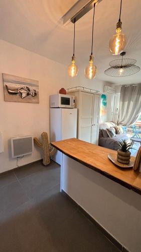 une cuisine avec un comptoir et une chambre avec un lit dans l'établissement Plages 130 m, parking privé, climatisé, wifi/fibre, à Valras-Plage