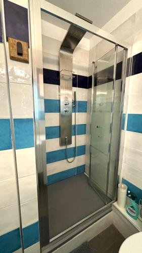 une salle de bain avec douche à rayures bleues et blanches dans l'établissement Plages 130 m, parking privé, climatisé, wifi/fibre, à Valras-Plage