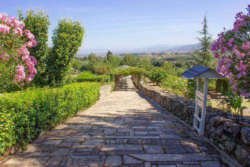 a stone path in a garden with flowers at Hotel Rural Casa de Samaioes in Chaves