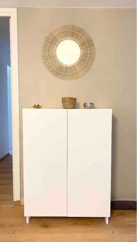 une armoire blanche avec un miroir au-dessus dans l'établissement Appt 4 pers-2 CHB-2 SDB-Piscine-Linge inclus-Literies faites à l'arrivée inclus-Parking, à Le Touquet-Paris-Plage