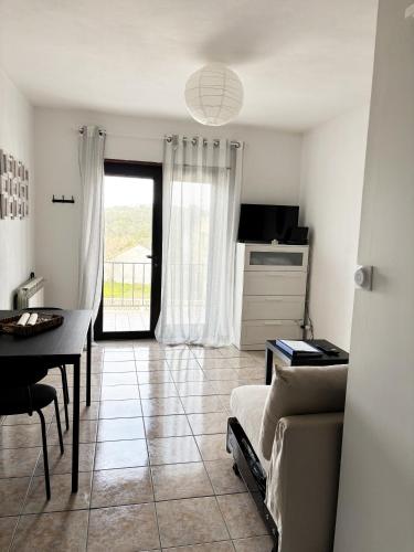 ein Wohnzimmer mit Couch und Tisch und eine Küche in der Unterkunft casa da serra in Boa Viagem