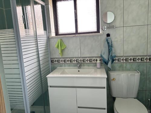 ein Badezimmer mit Waschbecken und Toilette und einem Fenster in der Unterkunft casa da serra in Boa Viagem