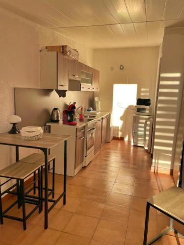 une cuisine avec une table et un réfrigérateur dans l'établissement Studio les pieds dans l eau, à Calvi