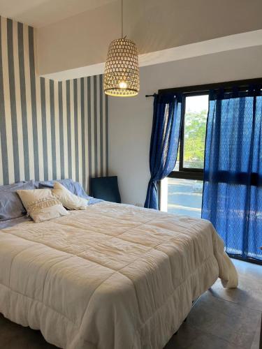 a bedroom with a large bed with blue curtains and a chandelier at Reina Victoria in San Juan