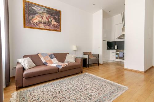 sala de estar con sofá marrón y alfombra en Riverside Palace Apartments, en Praga