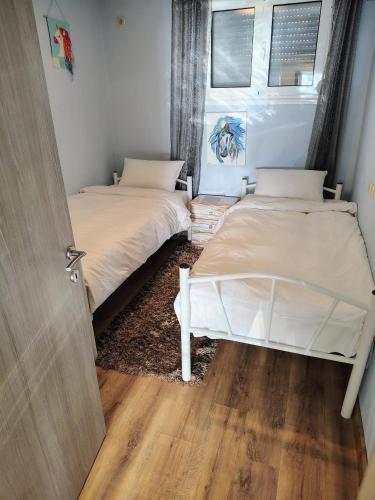 two beds in a small room with a door at Katia 's Country House in Sikión