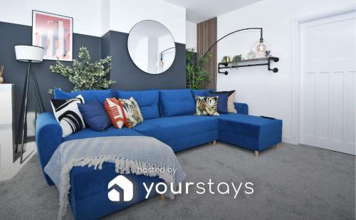 a blue couch with pillows in a living room at Lily House by YourStays - Cosy 3 Bedroom House in Crewe in Crewe