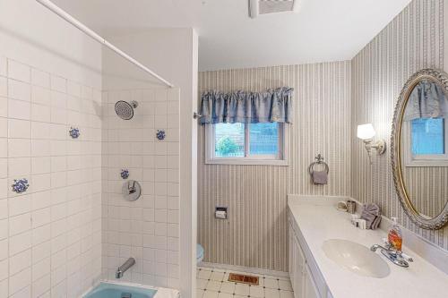 a bathroom with a tub and a sink and a mirror at Tolovana Treasure in Cannon Beach