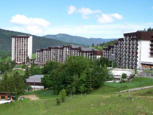 un groupe de bâtiments dans un champ vert planté d'arbres dans l'établissement Studio rénové au pied des pistes avec ascenseur à Villard de Lans - FR-1-515-105, à Villard-de-Lans