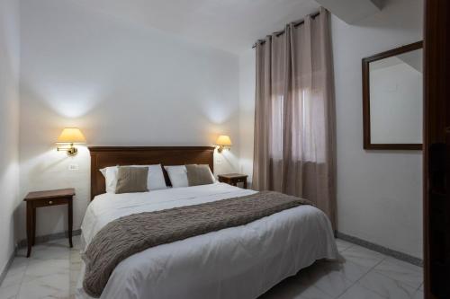 una camera da letto con un letto grande e due lampade di Royal Garden a Massa dʼAlbe