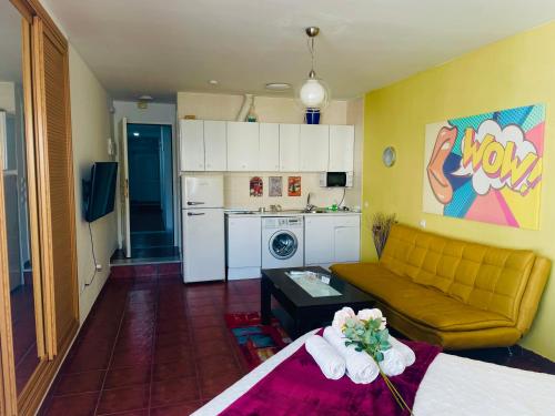 Una sala de estar con un sofá y una cocina. en Calm beach, en Torremolinos