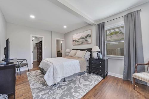 a bedroom with a bed and a desk and a television at Carytown Retreat Pet Friendly & Gourmet Kitchen in Richmond