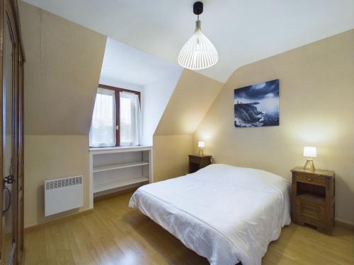 une chambre avec un lit blanc et une fenêtre dans l'établissement Maison idéale pour familles - Grand jardin, à Fouesnant