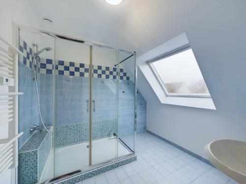 une salle de bain avec une douche en verre et un lavabo dans l'établissement Maison idéale pour familles - Grand jardin, à Fouesnant
