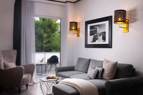 a living room with a couch and chairs and a window at Athenian Riviera Hotel& Suites in Athens