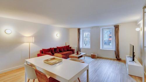 un salon avec un canapé rouge et une table dans l'établissement Le Rozé - Appart'Escale, à Saint-Nazaire
