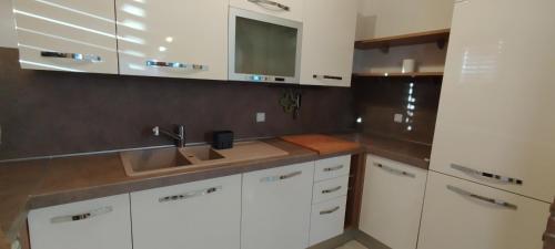 a kitchen with white cabinets and a sink at Apartment Lovor in Krk