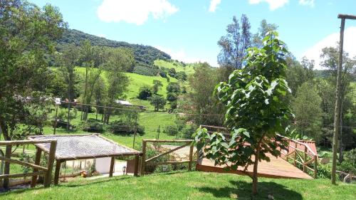 a garden with a wooden fence and a tree at Pousada Turmalina in Bueno Brandão
