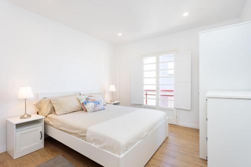 プエルト・デ・ラ・クルスにあるFamily Friendly Apartament Puerto de la Cruz Summa Hausの白いベッドと窓のある白い寝室