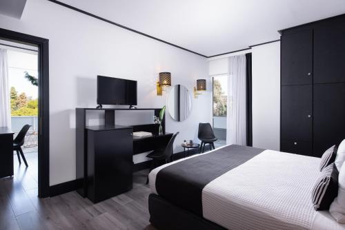 a bedroom with a bed and a desk with a piano at Athenian Riviera Hotel& Suites in Athens
