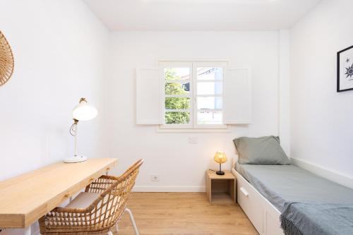 プエルト・デ・ラ・クルスにあるFamily Friendly Apartament Puerto de la Cruz Summa Hausの机とベッドと窓のある寝室