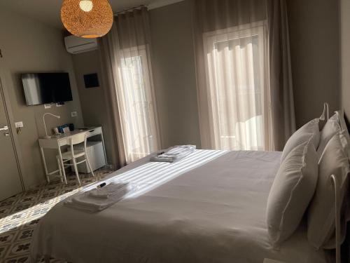 a bedroom with a white bed and a window at Moronero in Ragusa