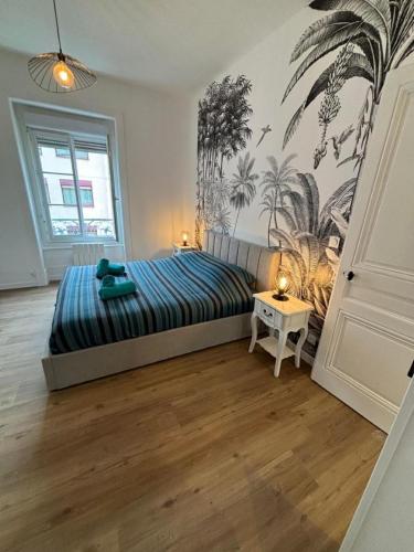 - une chambre avec un lit doté d'une couette bleue et d'une table dans l'établissement Superbe T2, rénové, calme, à Villeurbanne