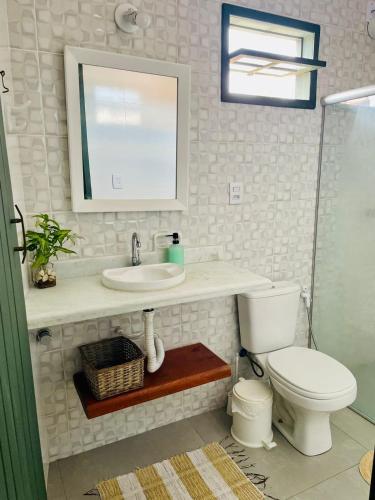 a bathroom with a toilet and a sink and a mirror at Casa Pau Brasil in Prado