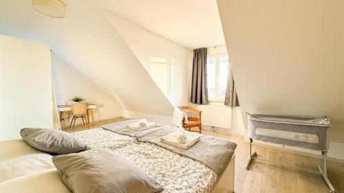 a white bedroom with a bed in a room at Vienna's Nature Corner - charming rooftop family apartment in Gerasdorf bei Wien