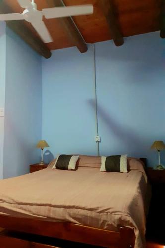 a bedroom with a large bed with a ceiling fan at Departamento Dharma in Capilla del Monte